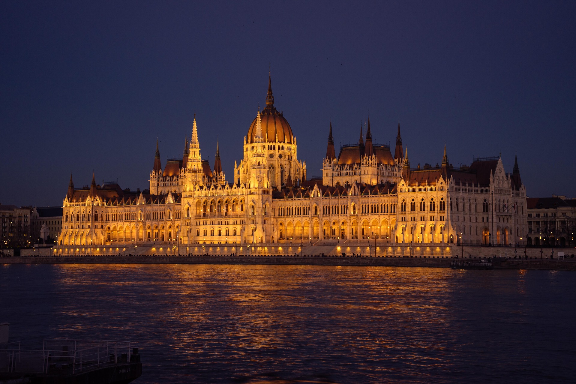 Das Bild zeigt das nächtlich beleuchtete Parlament von Budapest – ein Wahrzeichen der Stadt direkt an der Donau, eindrucksvoll in Szene gesetzt.