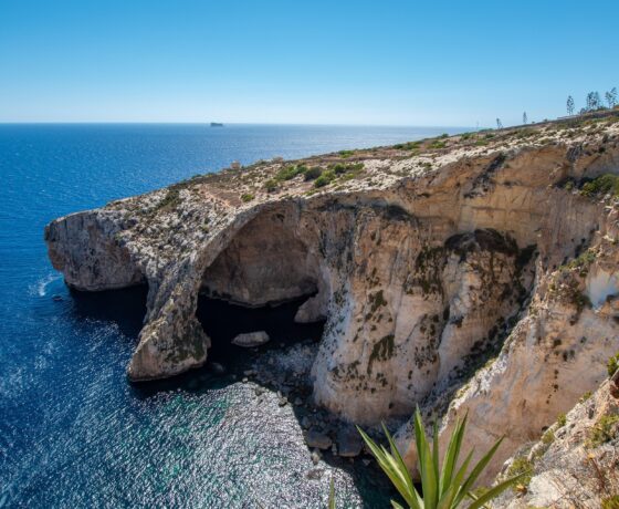 Felsige Küste mit Höhlen und klarem, blauem Meer unter strahlend blauem Himmel auf Malta.